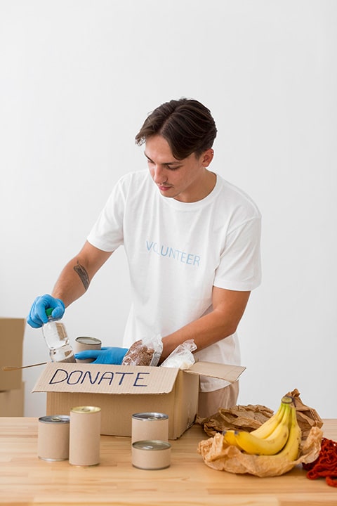 man-placing-goodies-donation-boxes