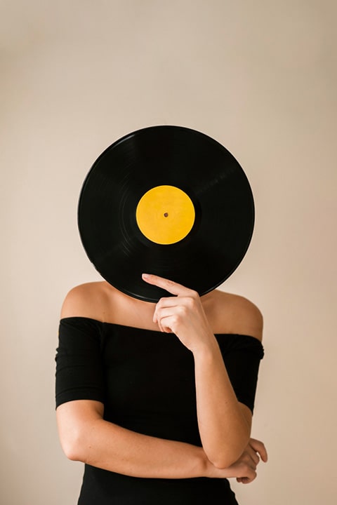 young-woman-holding-vinyl-record-her-face